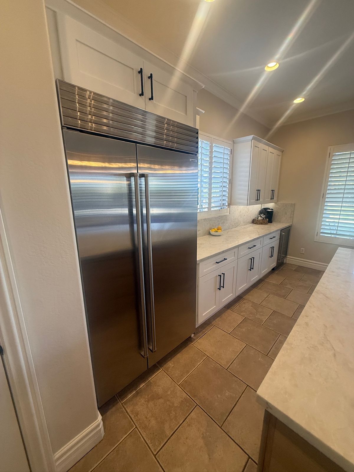 Stanley Brothers project: a built-in refrigerator flanked by full height cabinetry along a galley run